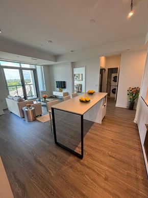 Mississauga apartment for rent - A modern kitchen with a large island and a view of the outdoors.