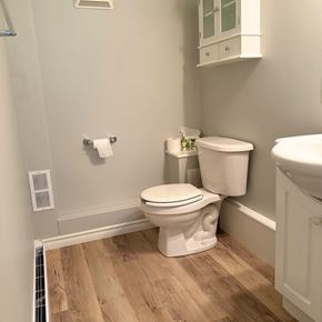 Brandon apartment for rent - A white toilet sits in a bathroom next to a white sink.