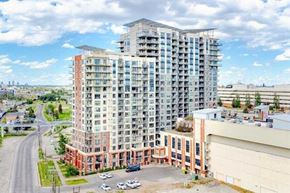 Calgary house for rent - A large multi-story building with a parking lot in front.