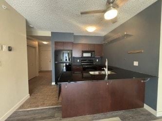 Calgary house for rent - A kitchen with a black counter top and a fan on the ceiling.