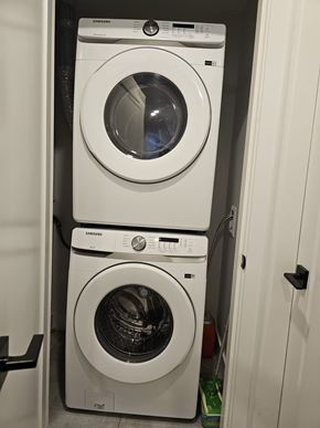 Chilliwack house for rent - Two white Samsung front load washing machines stacked on top of each other in a small laundry room.