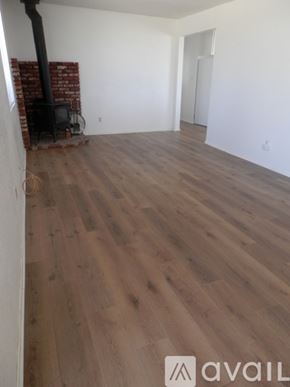 Landers apartment for rent - A room with a wood floor and a brick fireplace.