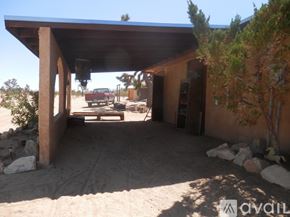 Landers apartment for rent - A house with a covered patio area and a red truck parked in the background.