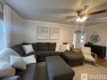 Midland house for rent - A living room with a grey sofa and a white chair.