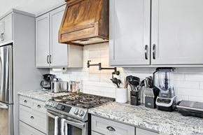 Keller house for rent - A kitchen with a stove top and a refrigerator.