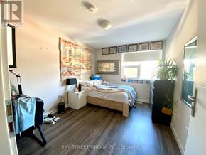 Waterloo townhouse for rent - A bedroom with a bed, nightstand, and chair.