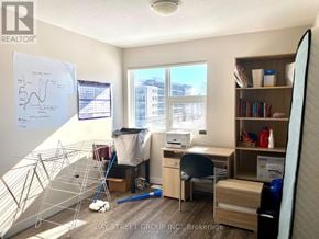 Waterloo townhouse for rent - A room with a whiteboard, desk, and a window overlooking a cityscape.