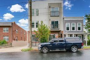 Washington apartment for rent - A blue SUV is parked in front of a modern apartment building.