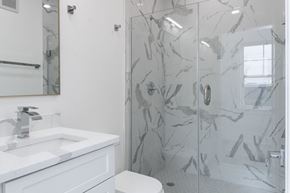Washington apartment for rent - A bathroom with a marble patterned shower stall.