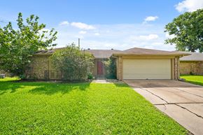 Houston house for rent - A house with a brown roof and a white garage door.