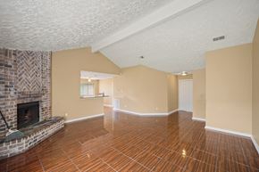 Houston house for rent - A living room with a fireplace and wood flooring.