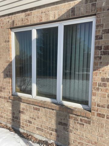 Moorhead house for rent - A window with white frames and a glass pane is on a brick wall.
