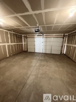 Cedar City townhouse for rent - A spacious garage with a closed white door and a light on the ceiling.