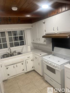 Alhambra house for rent - A kitchen with white cabinets and a stove top oven.