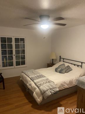 Alhambra house for rent - A bedroom with a bed, a ceiling fan, and a window.