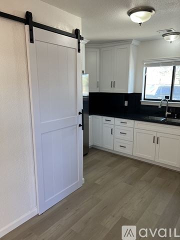 Livermore house for rent - A kitchen with white cabinets and a black bar.