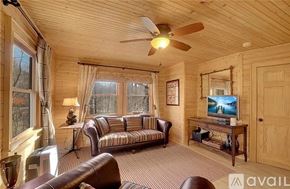 Sylva apartment for rent - A living room with a couch, a television, and a ceiling fan.