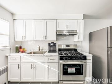 Oaklyn apartment for rent - A kitchen with white cabinets and a stainless steel refrigerator.