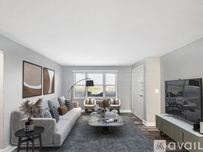 Oaklyn apartment for rent - A living room with a grey couch, a coffee table, a television, and a window.