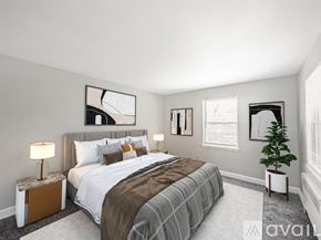 Oaklyn apartment for rent - A bedroom with a large bed and a plant on the side table.