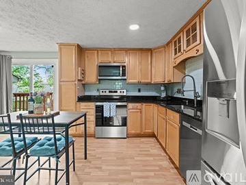 Waldorf house for rent - A kitchen with wooden cabinets and a black countertop.