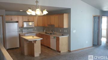 Moorhead house for rent - A kitchen with wooden cabinets and a white fridge is available for rent.