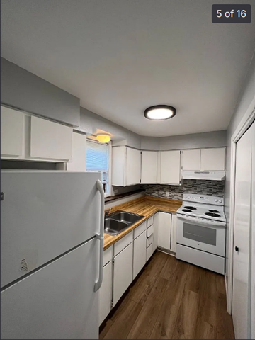 Wausau apartment for rent - A kitchen with white appliances and wooden floors.