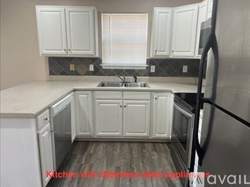Anderson house for rent - A kitchen with white cabinets and a wooden floor.