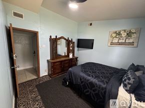 Orlando apartment for rent - A bedroom with a bed, a dresser, and a mirror.