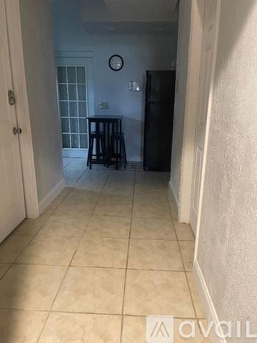 Orlando apartment for rent - A kitchen with a fridge and a clock on the wall.