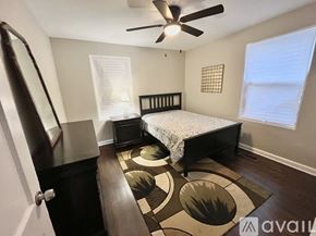 Decatur house for rent - A bedroom with a bed, dresser, and a rug with circular designs.