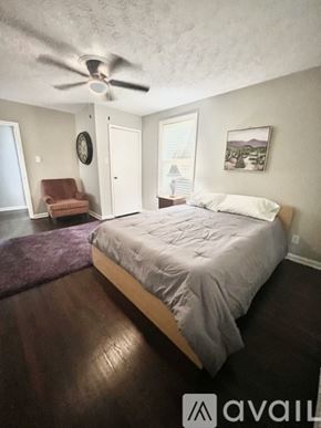 Decatur house for rent - A bedroom with a bed, chair, and window.