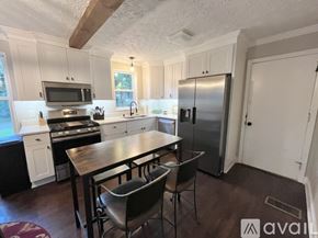 Decatur house for rent - A kitchen with a table and chairs in front of a refrigerator.