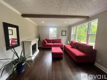 Decatur house for rent - A living room with red couches and a fireplace.