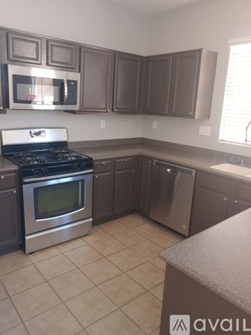 Victorville house for rent - A kitchen with a stove top oven and microwave.