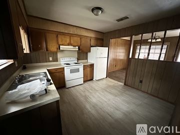 Meridian house for rent - A kitchen with wooden cabinets and a white refrigerator.