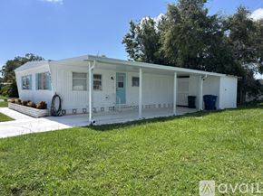 Sarasota apartment for rent - A white mobile home with a blue door and windows.
