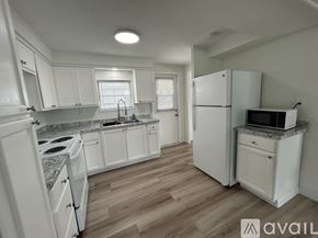 Sarasota apartment for rent - A kitchen with white cabinets and a granite countertop.