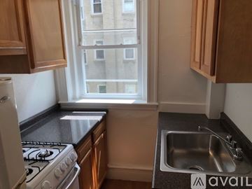 Boston apartment for rent - A kitchen with a stove, sink, and window.