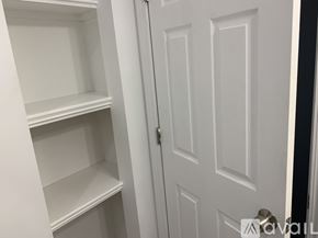 Salisbury apartment for rent - A white door is open to a white pantry with empty shelves.
