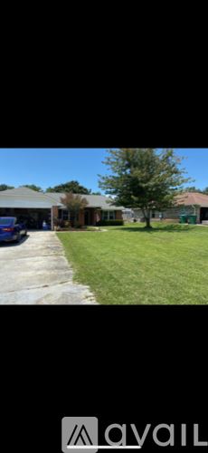 Navarre house for rent - A grassy area in front of a building with a tree.