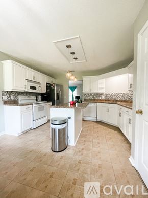 Navarre house for rent - A kitchen with white cabinets and a tiled floor.