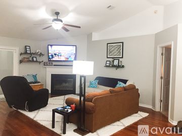 Navarre house for rent - A living room with a black chair, a brown couch, and a fireplace.