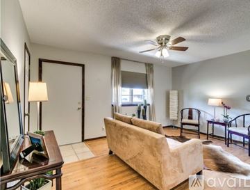 Mustang house for rent - A living room with a beige couch and a ceiling fan.