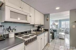 Myrtle Beach condo for rent - A kitchen with white cabinets and a stove top oven.