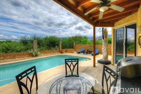 Oro Valley house for rent - A poolside patio with a table and chairs.