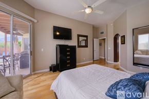 Oro Valley house for rent - A bedroom with a large bed and a flat screen TV mounted on the wall.