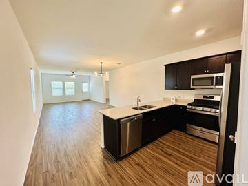 Pflugerville house for rent - A kitchen with dark wood cabinets and stainless steel appliances.