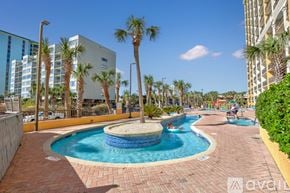 Myrtle Beach condo for rent - A swimming pool surrounded by palm trees and a building in the background.