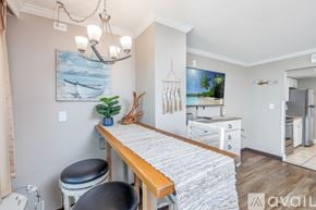 Myrtle Beach condo for rent - A kitchen with a wooden table and a painting of a beach scene on the wall.